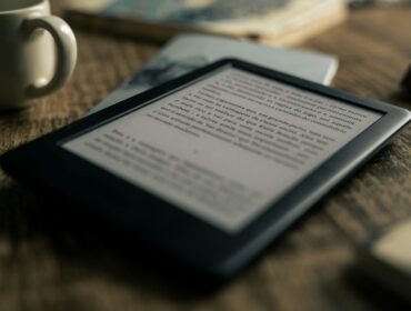 A tablet displaying an ebook on a wooden table next to a coffee cup, ideal for tech and lifestyle themes.